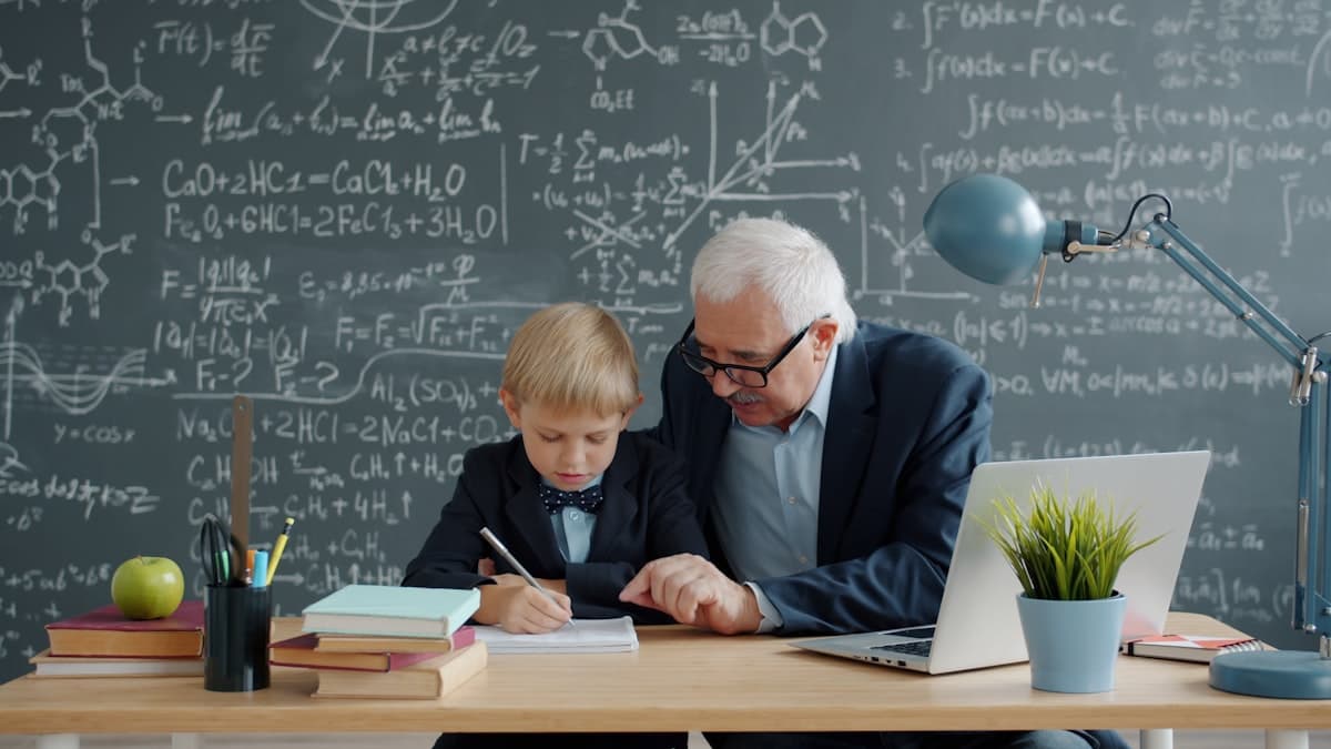 Educador apoiando um aluno em atividade de aprendizado com notebook e caderno